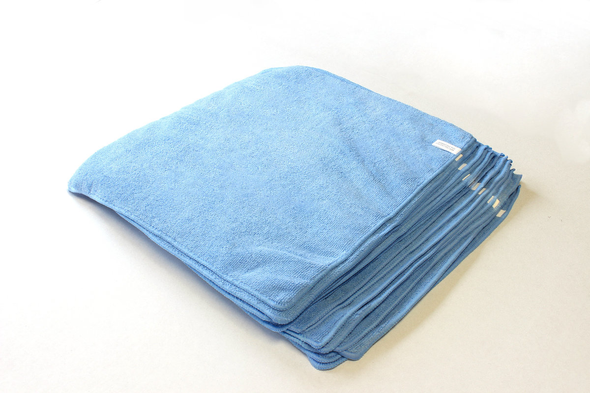 Stack of reusable blue microfiber cloths for commercial cleaning and janitorial services